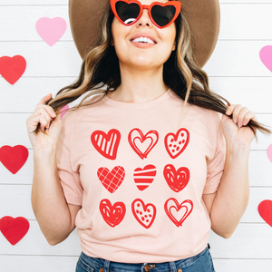 peach unisex  shirt with 9 red hearts in various styles