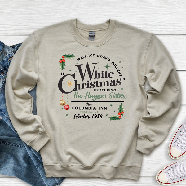 Beige sweatshirt with Christmas-themed text and graphics on a white wooden surface.