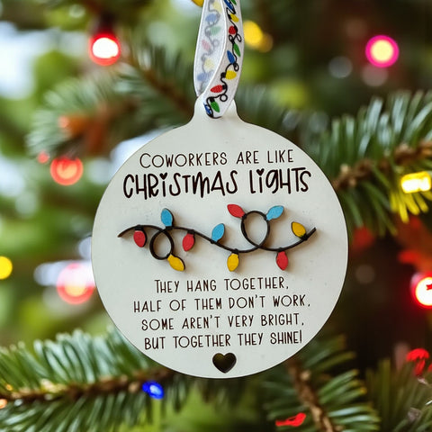 Ornament with Christmas lights design and humorous coworker quote on a tree.