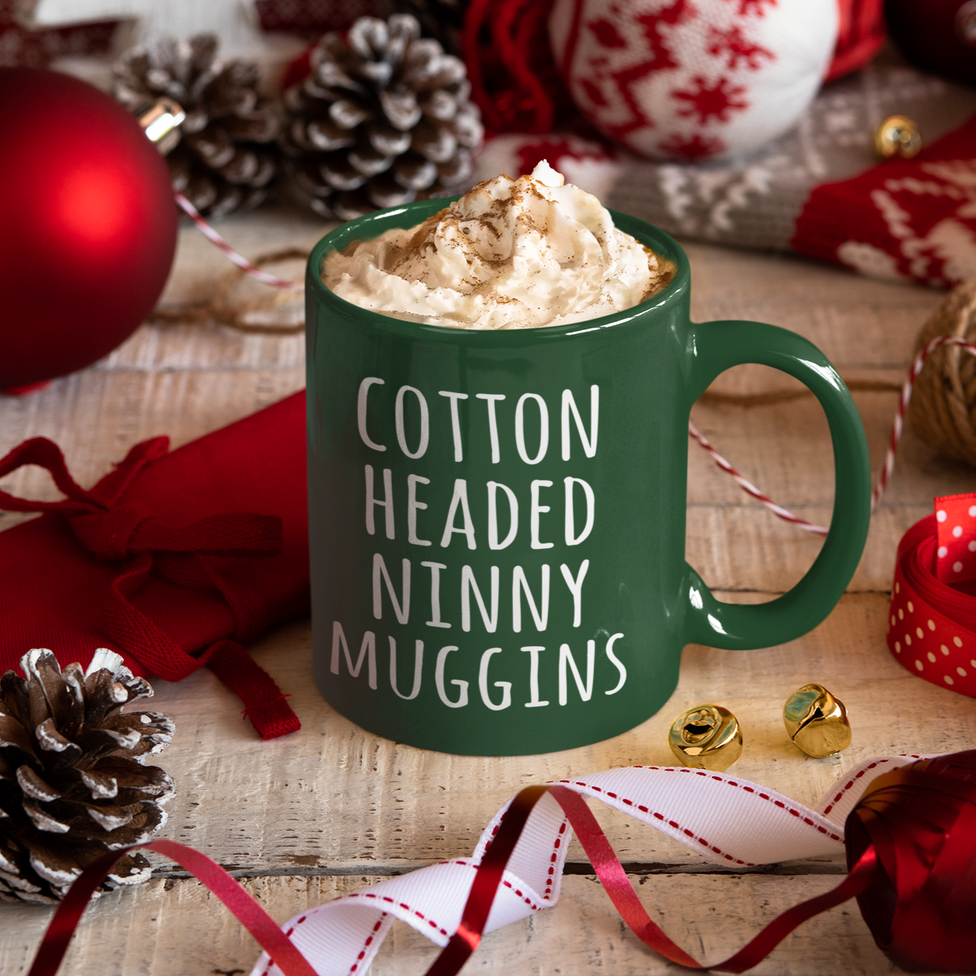 dark green christmas mug with white print that says Cotton Headed Ninny Muggins