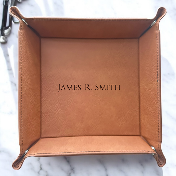 Brown leather tray with 'JAMES R. SMITH' engraving on a marble surface