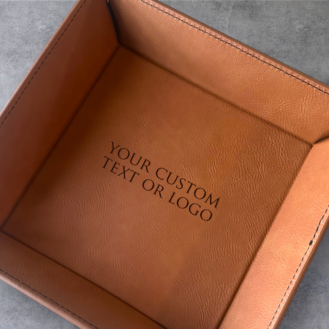 Brown leather tray with customizable text or logo on a gray surface